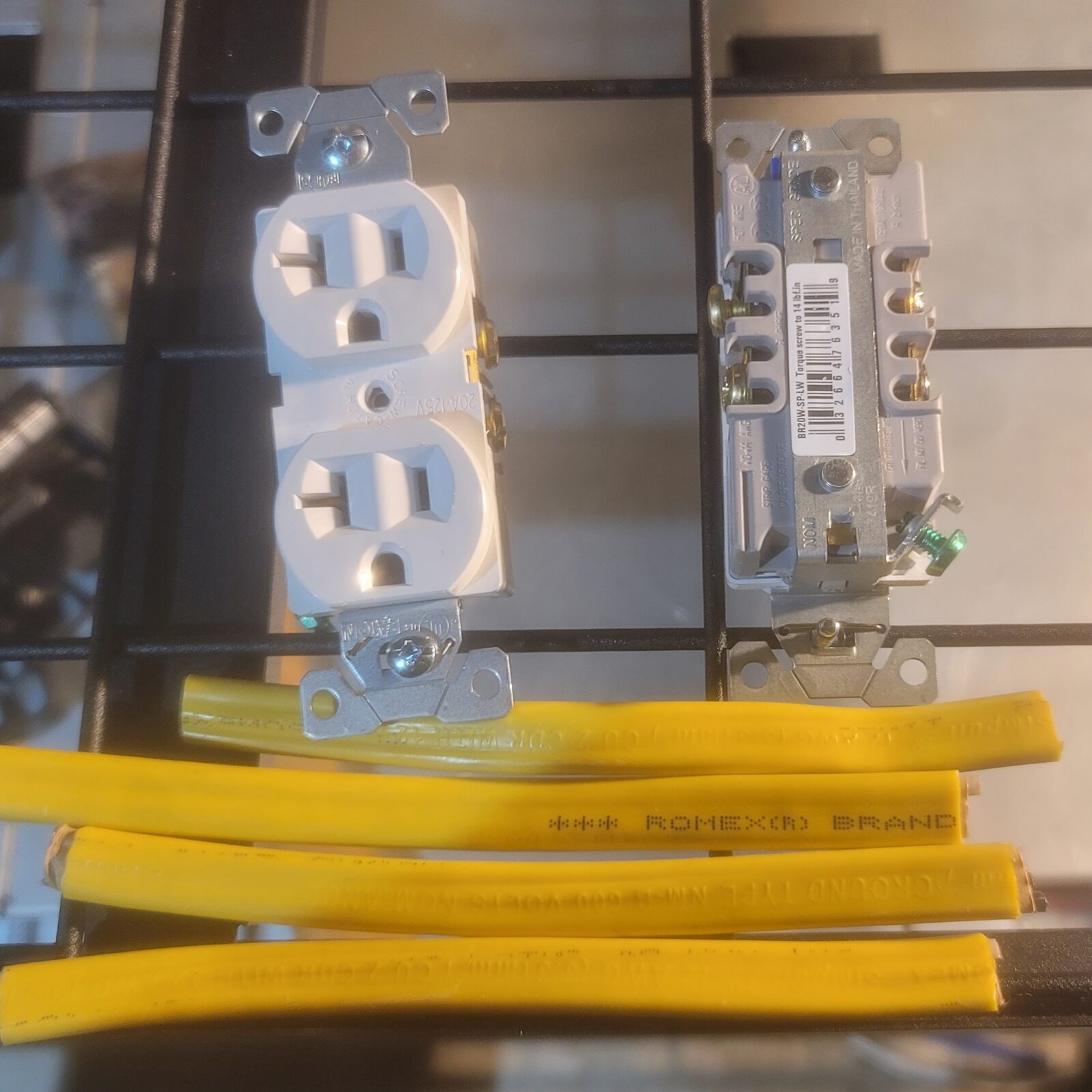Two 20 amp duplex receptacles beside four short lengths of yellow Romex