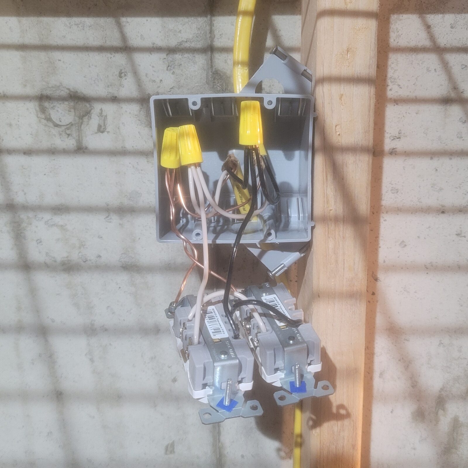 A box with yellow cable entering above & continuing below, wire nuts joining both runs to the receptacles