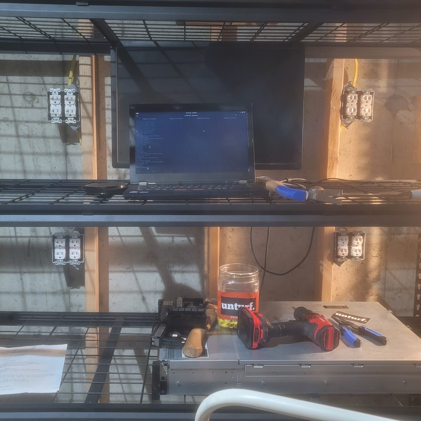 The finished wall: four boxes, eight duplex receptacles, a rack server on the bottom shelf